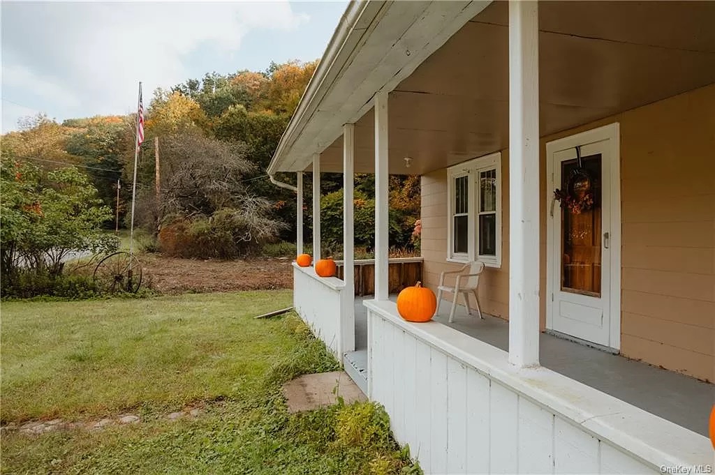 Porch from side with pumpkins on the ledge